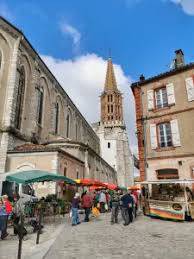 Vue du centre-ville animé de Caussade, entre patrimoine et commerces de proximité.